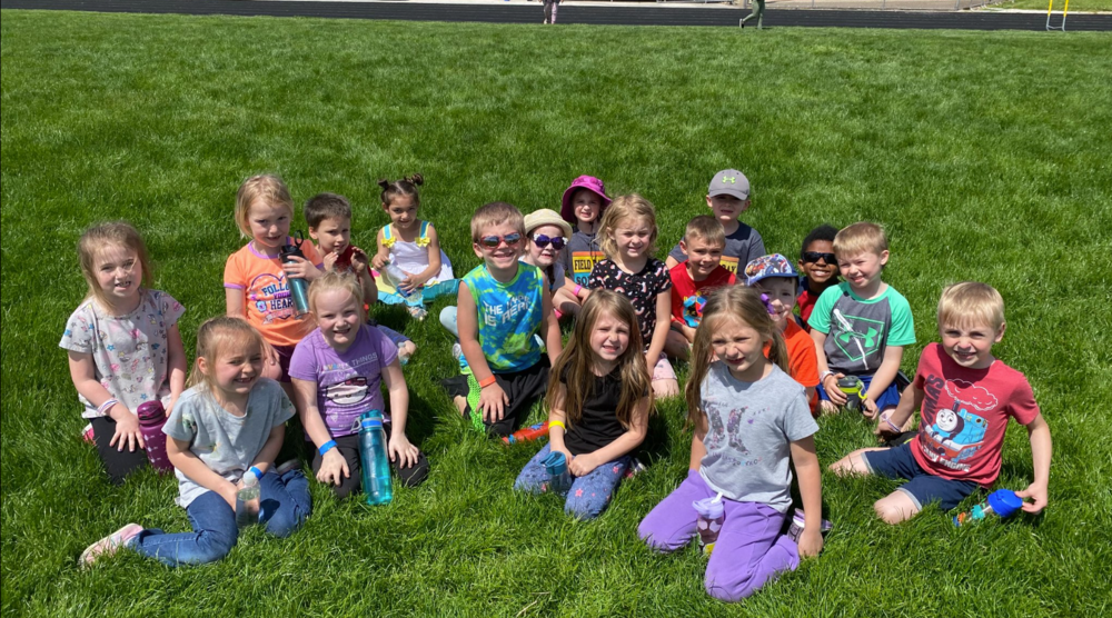 A group of young children sitting on the grass