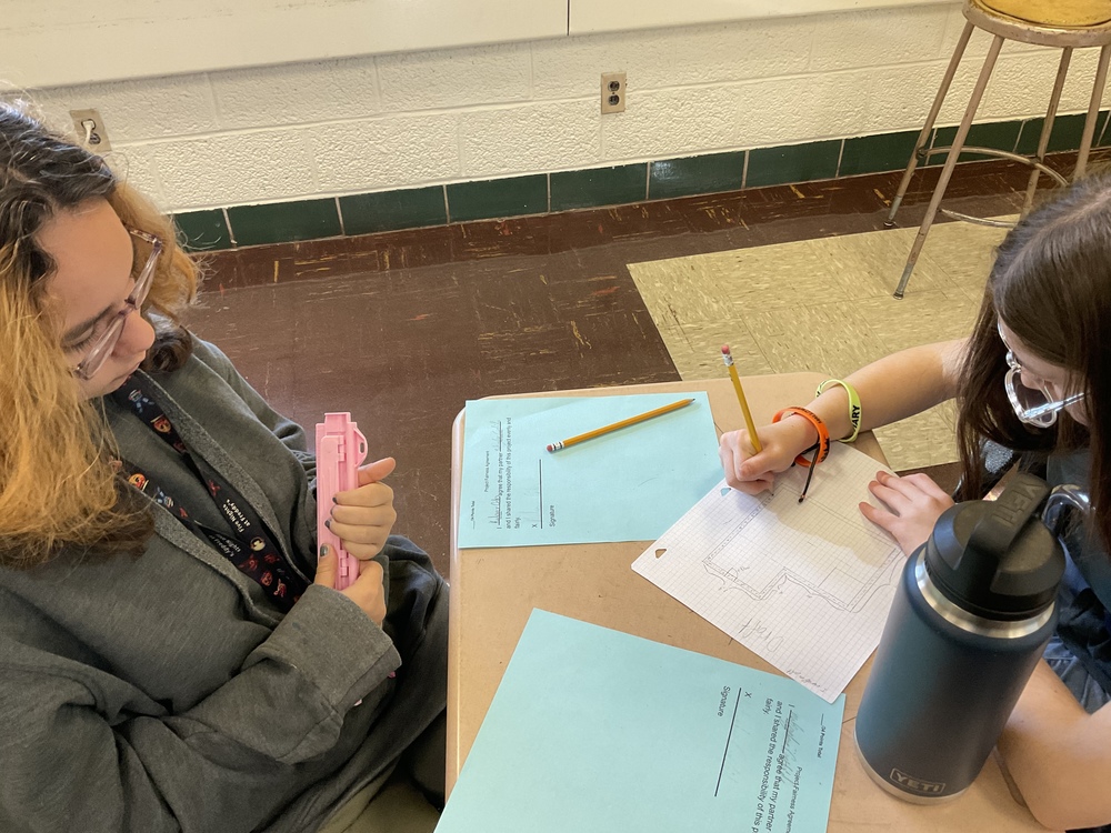 Two students working together to create a blueprint for a home.